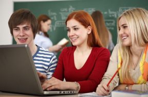 Group of students using laptop in classroom